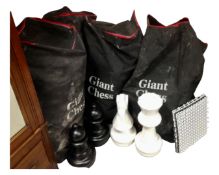Four bags containing a giant chess board and pieces.
