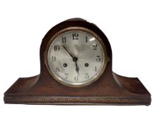 An oak cased eight day mantel clock with silvered dial.