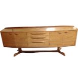 A 20th century Chapmans Siesta teak bow fronted teak four door sideboard fitted with three central