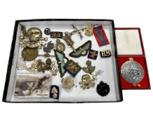 A quantity of period and later military cap badges and other decorations,