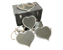A contemporary trunk containing seven heart shaped mirrors in metal frames.