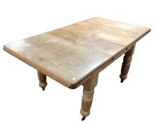 A Victorian pine extending kitchen table with two leaves together with a set of four antique pine