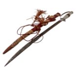 An African sword in tasselled leather sheath.