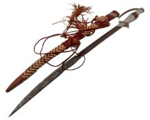An African sword in tasselled leather sheath.