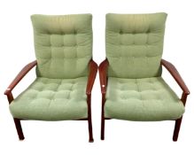 A pair of mid-20th century Cintique armchairs upholstered in a green fabric.