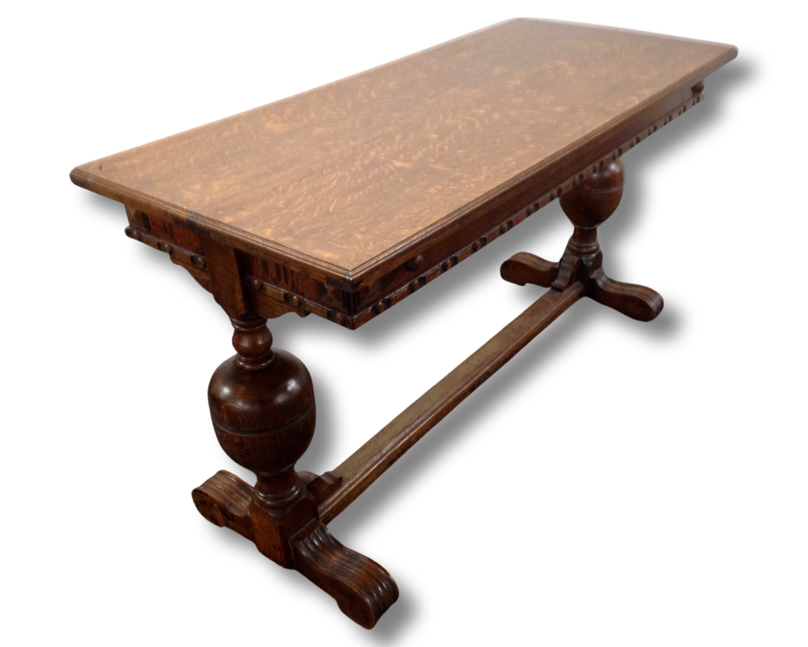 An Edwardian oak extending refectory dining table on bulbous legs.