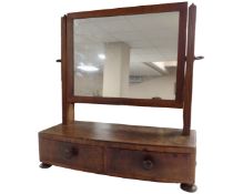 A George III mahogany toilet mirror fitted with two drawers.