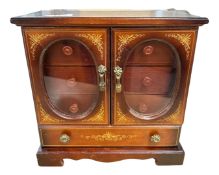 A wooden double glazed door musical jewellery cabinet, fitted internally with three drawers,