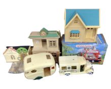 A quantity of Sylvanian Families toys including caravan, country bus, ambulance, nursery and school.