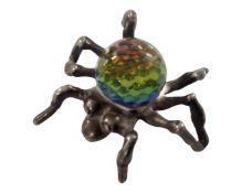 A silver spider with an inset crystal stone.