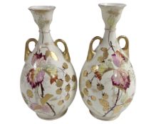 A pair of antique twin handled vases with gilded decoration.