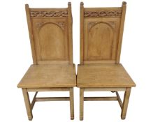 A pair of mid-20th century oak ecclesiastical chairs.