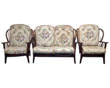 An Ercol elm and beech three piece wing back lounge suite in an antique finish.