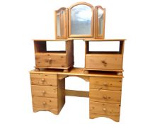 A pine twin pedestal dressing table with triple mirror together with a pair of similar pine bedside