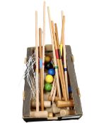 A box containing croquet equipment including mallets, pegs, hoops and balls.