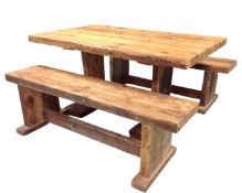 A chunky pine refectory dining table together with two benches.