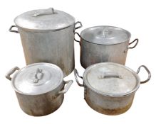 Four graduated aluminium cooking pots with lids.