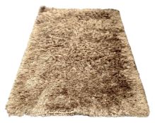 A contemporary shaggy piled brown rug