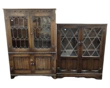 An oak linen fold bookcase with leaded glass doors together with a further bookcase with leaded