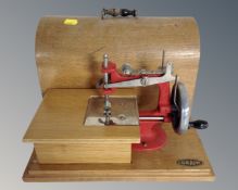 A mid-20th century Grain toy sewing machine in case.