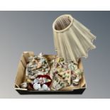A box containing Italian figurines, a figural table lamp, wall pocket and plaque.