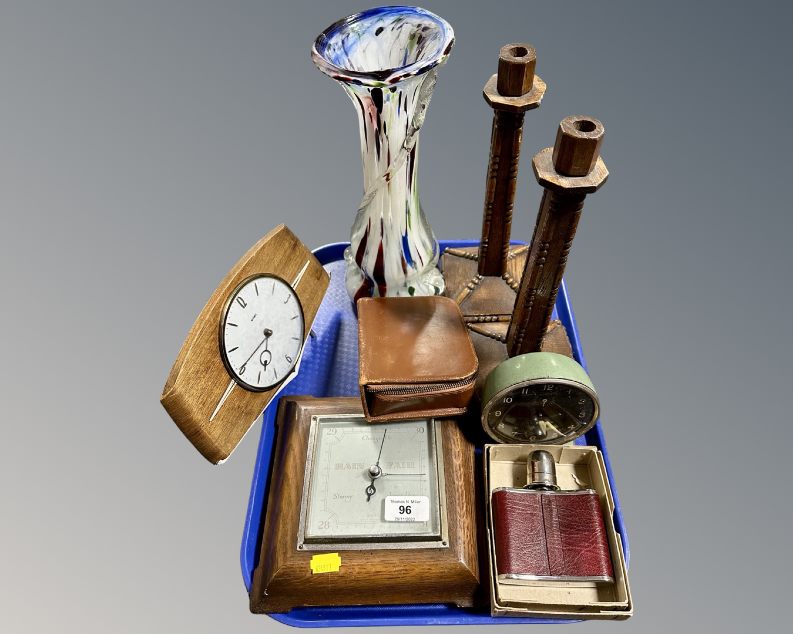 A tray containing a mid-20th century mantel clock, a pair of Edwardian oak candlesticks,