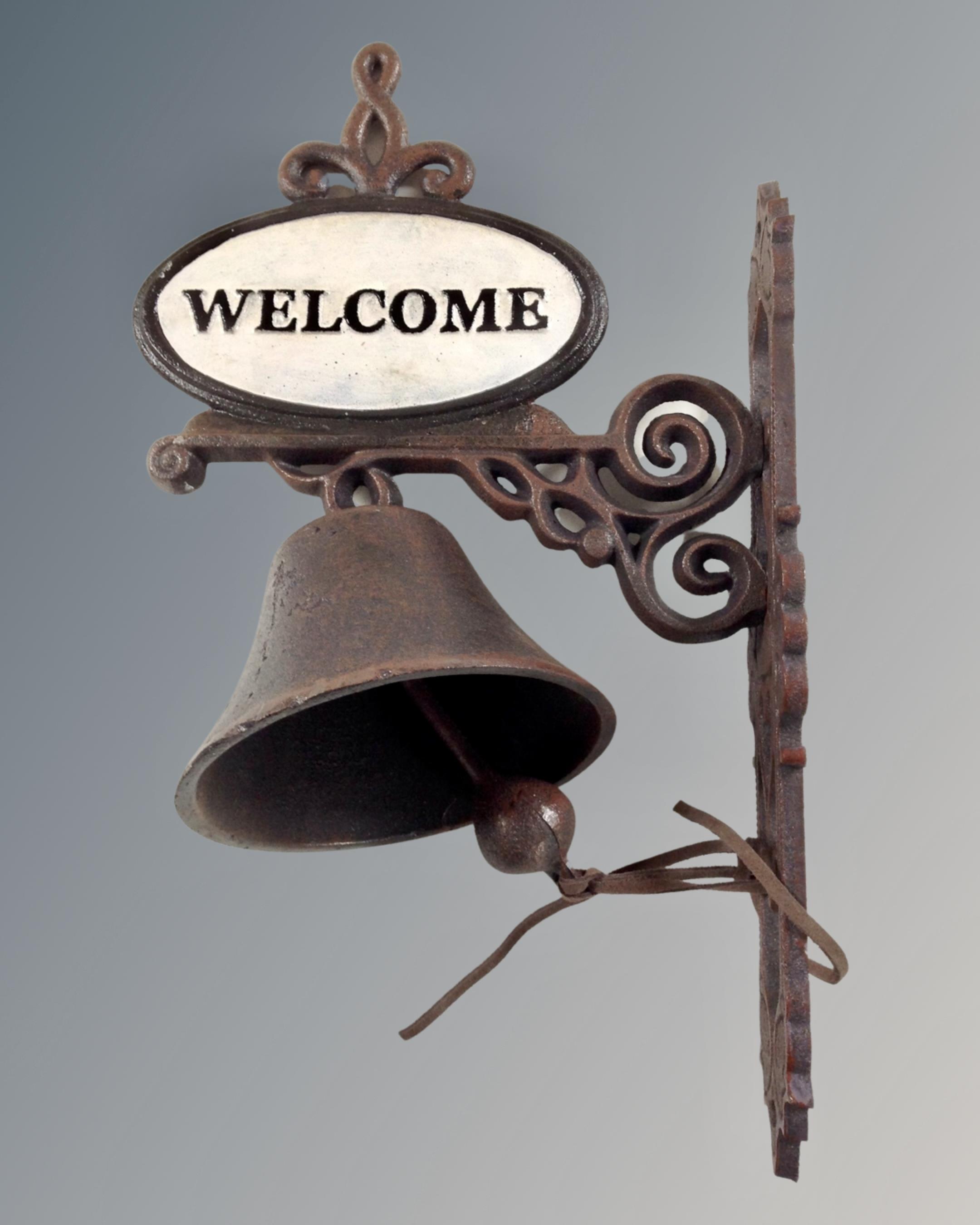 A cast iron welcome wall bracket with bell.