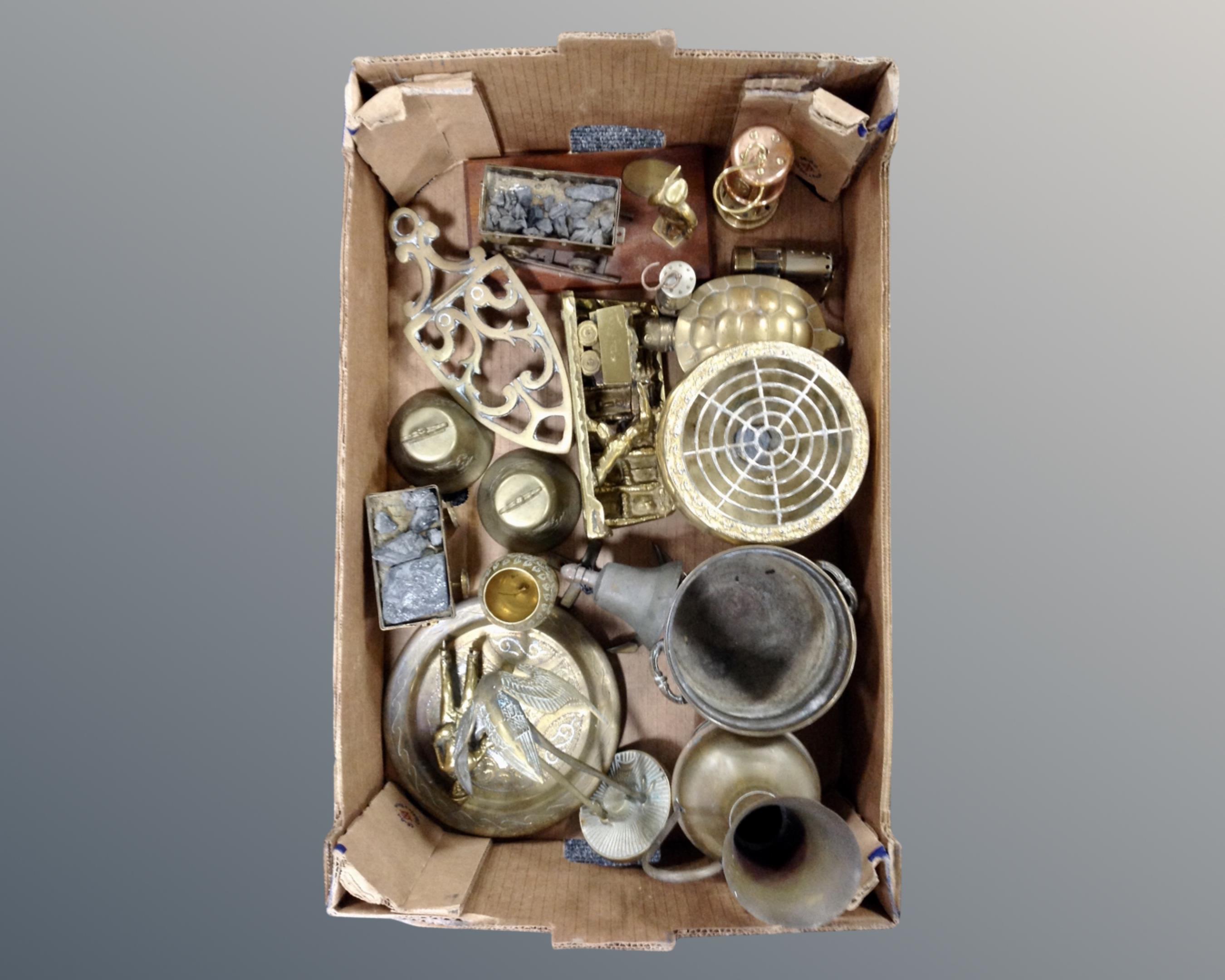 A box containing copper and brass wares including a miniature miner's lamp, mining figures, trivet,