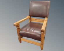 A 20th century carved oak armchair upholstered in brown leather.