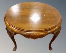 A continental carved beech circular coffee table on cabriole legs.