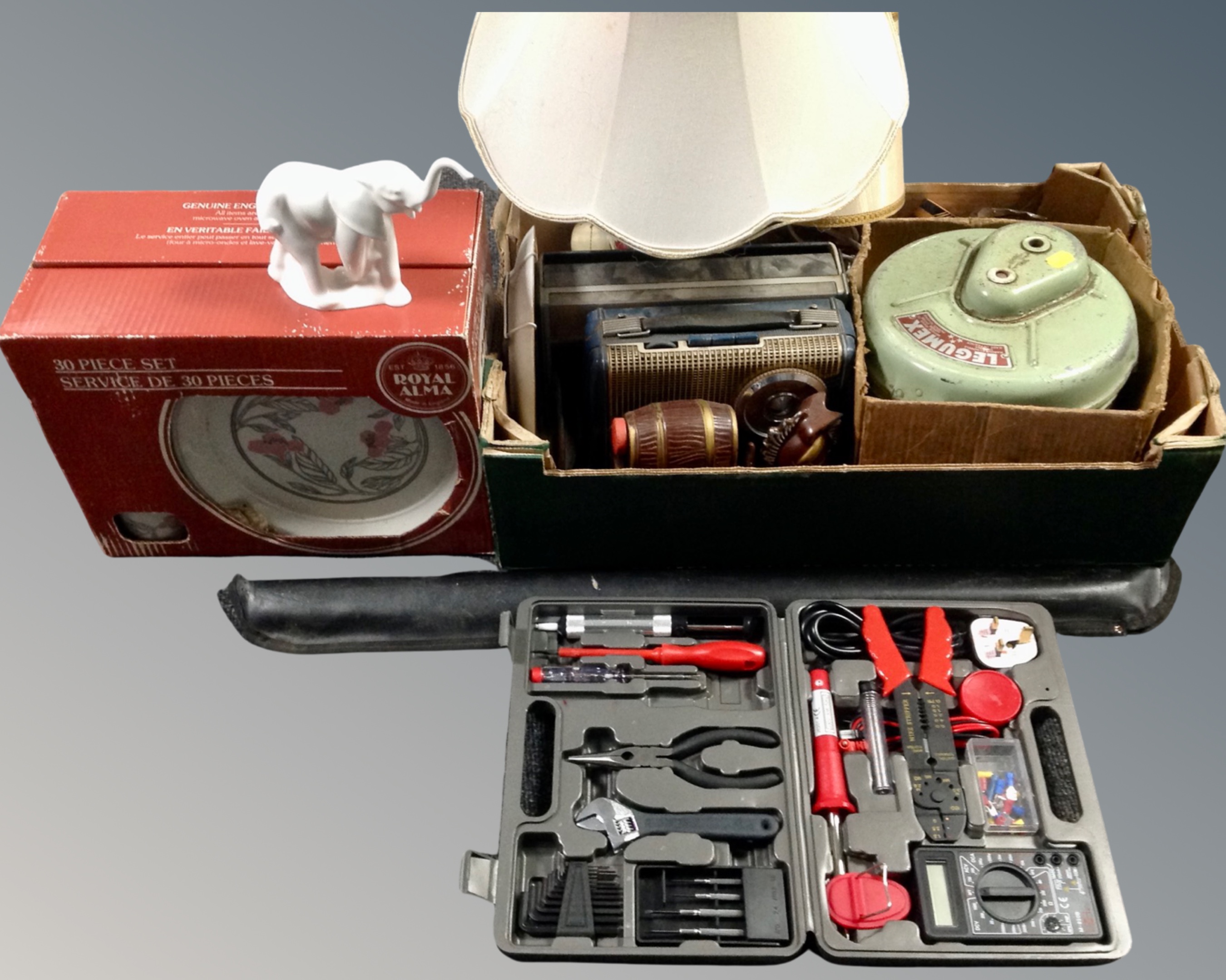 A box containing vintage radios, a porcelain table lamp with shade, snooker cue,
