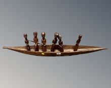 A hardwood African tourist carving of six figures in a boat.