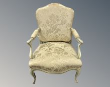 A French Louis XV style cream and gilt open armchair.