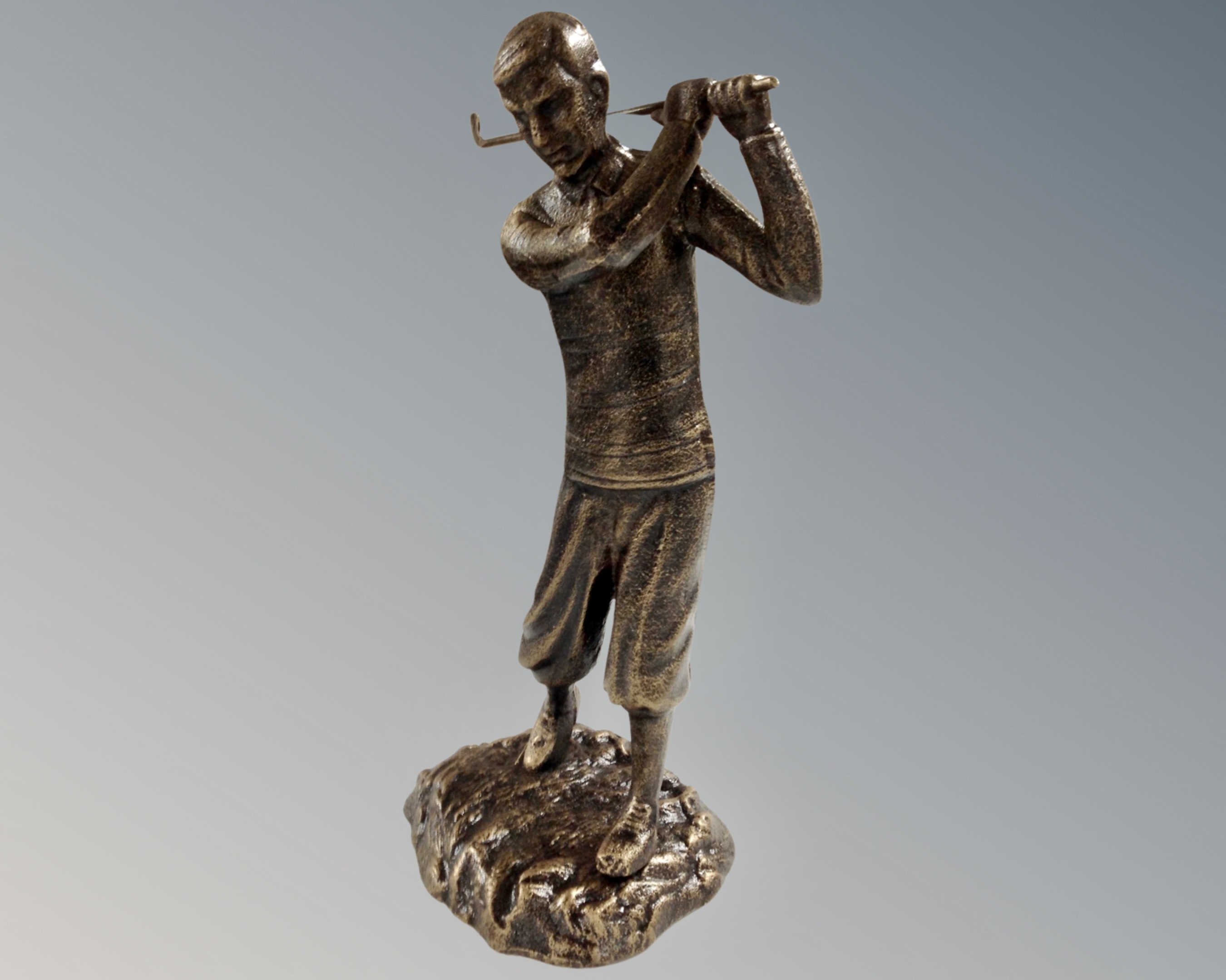 A cast iron figure of a golfer in bronzed finish