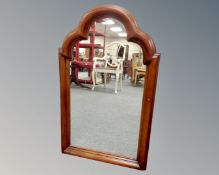 An arch topped mirror in stained beech frame.