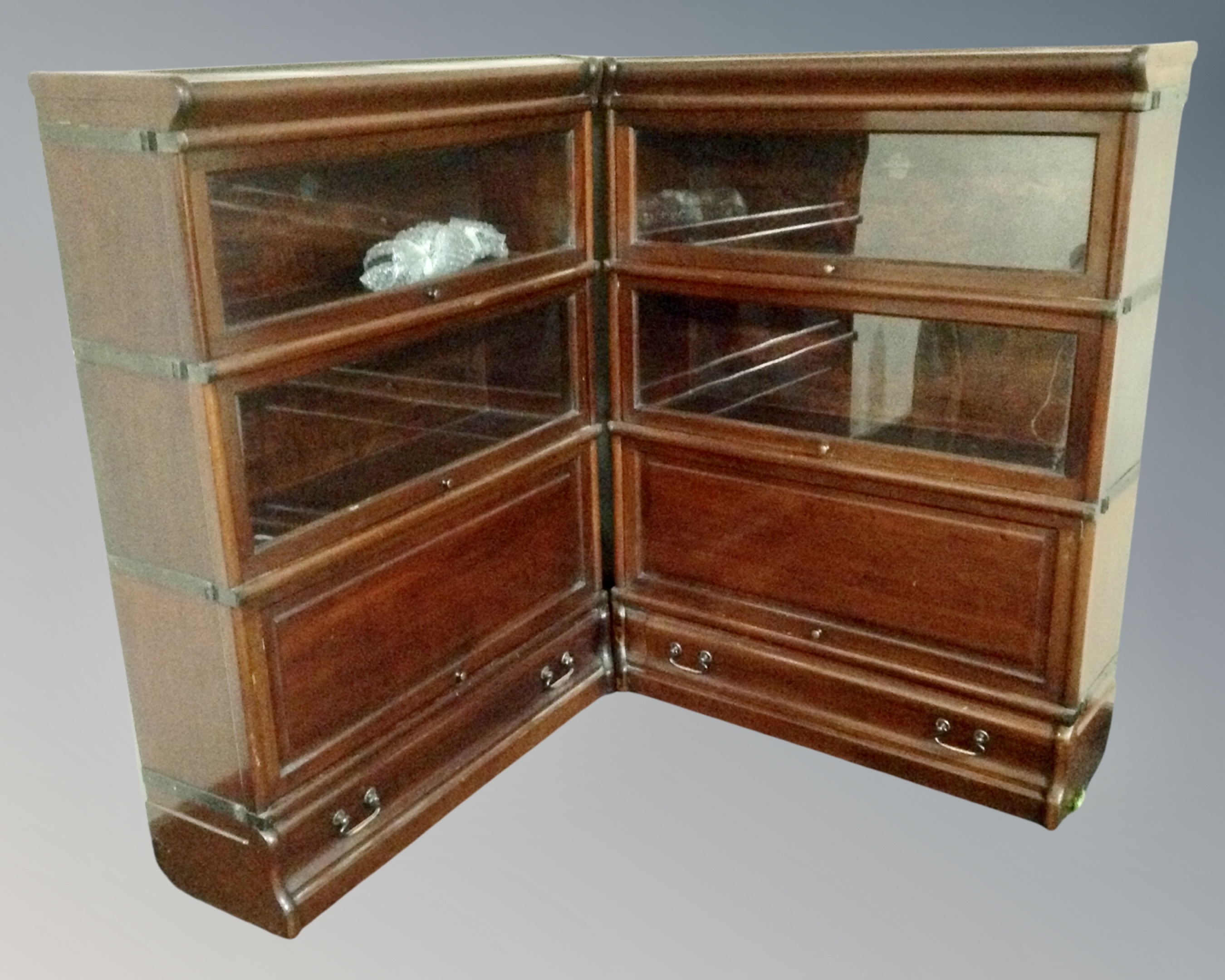 A Globe Wernicke three-tier corner stacking twin-section bookcase fitted with drawers beneath.