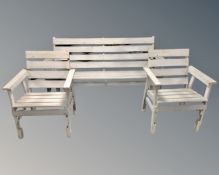 A painted wooden slatted garden bench with matching armchairs