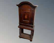 A 19th century inlaid oak cabinet fitted with a drawer on raised barley twist legs.
