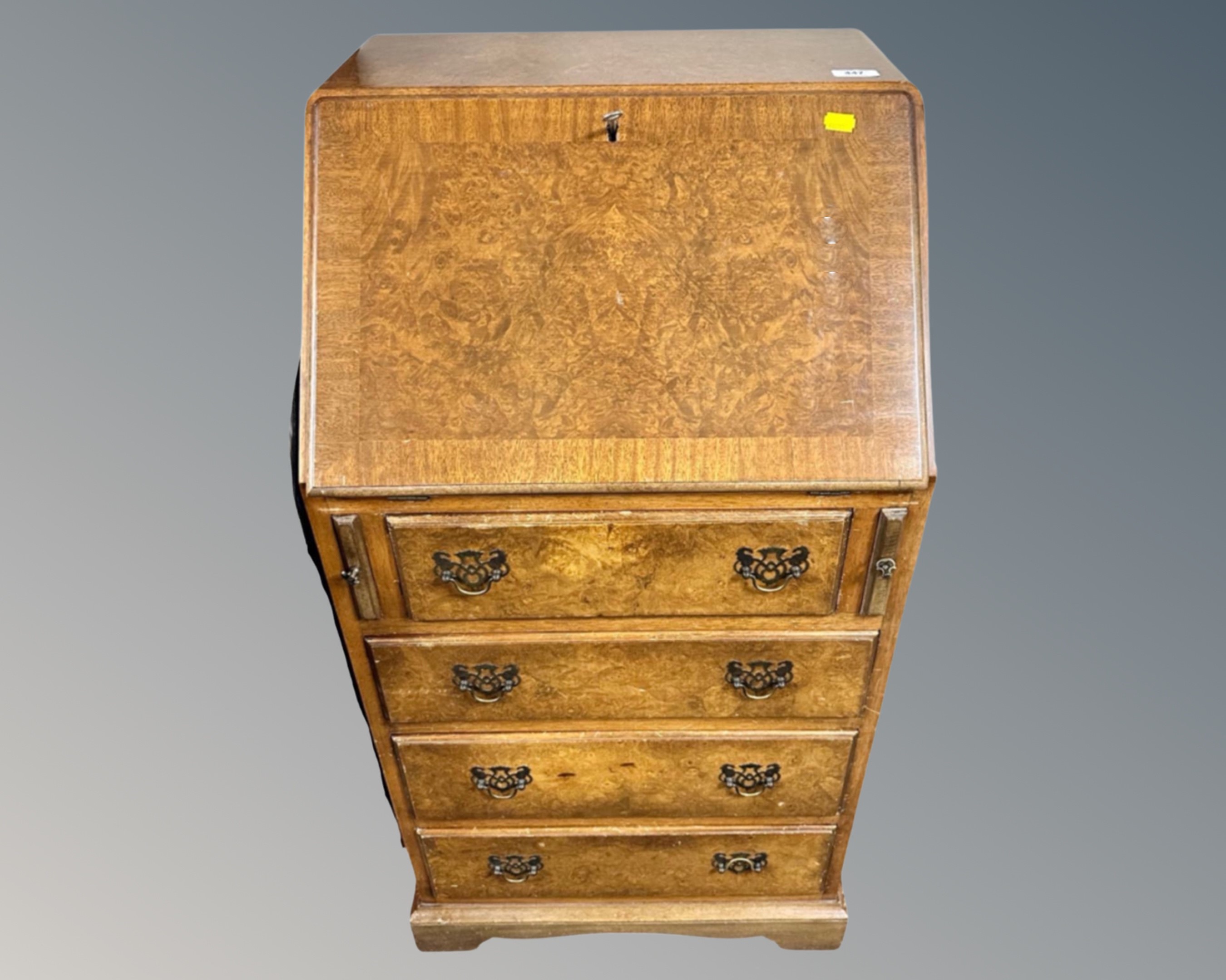 A burr walnut writing bureau fitted with four drawers beneath.