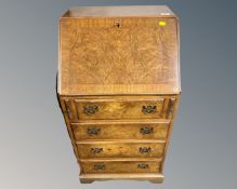 A burr walnut writing bureau fitted with four drawers beneath.