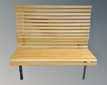 A 20th century beech wooden slatted bench on metal legs.