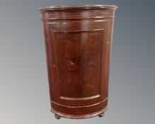 A 19th century bowfront corner cabinet.