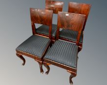 A set of four early 20th century continental mahogany panel backed dining chairs on cabriole legs.