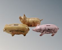 Three cast iron pig money boxes.