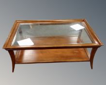 A contemporary glass topped two tier rectangular coffee table in a mahogany finish.