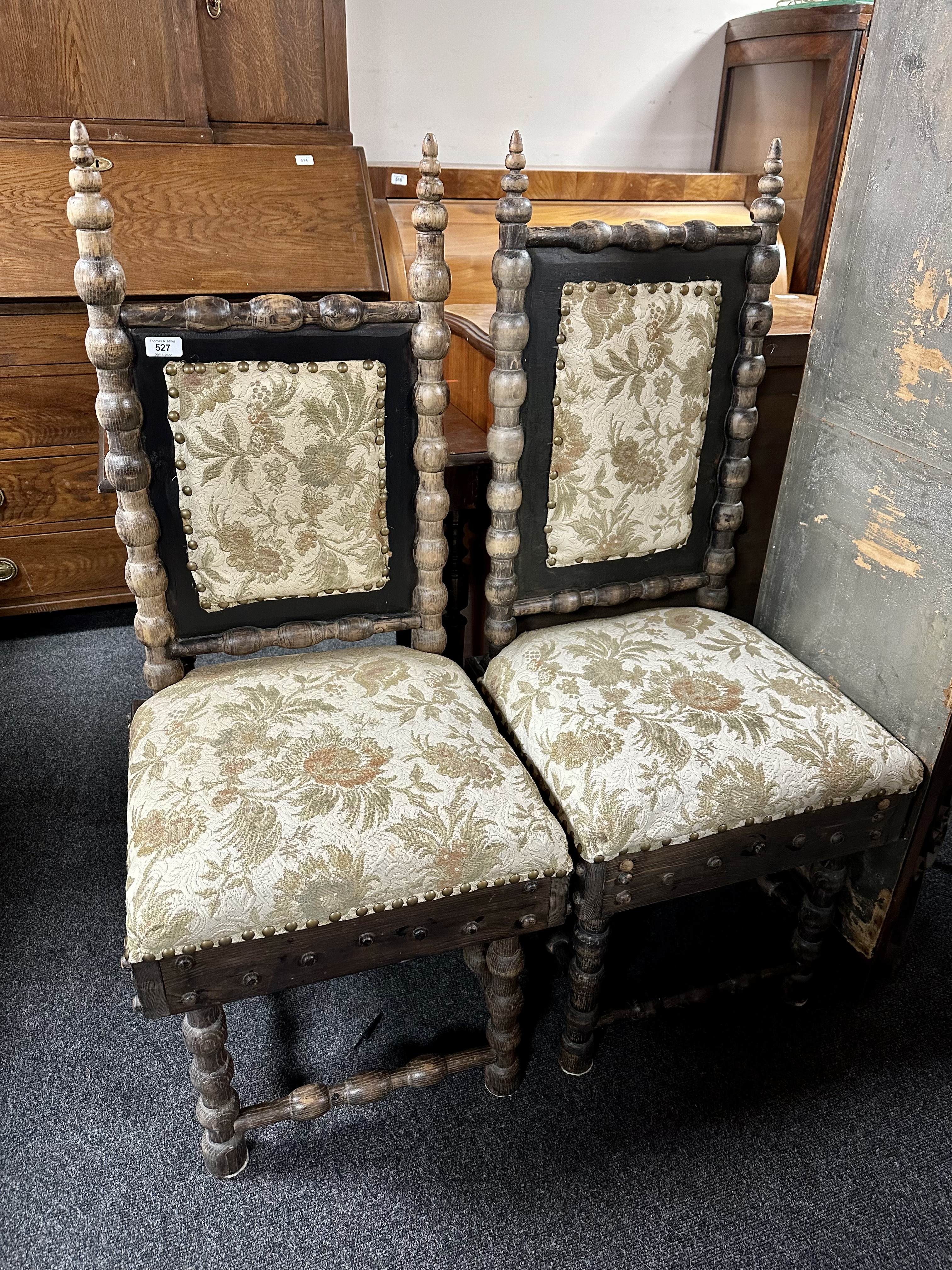 A pair of lady's and gent's bobbin-turned chairs upholstered in a floral fabric.