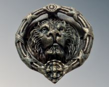 A cast iron lion head door knocker, width 21 cm.