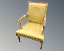 A painted Scandinavian armchair upholstered in yellow fabric.