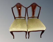 A pair of antique mahogany dining chairs on cabriole legs.