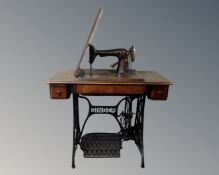 A Singer treadle sewing machine in table.